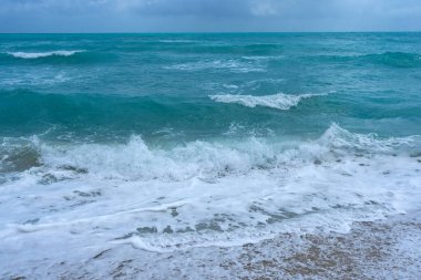 Kristal deniz kıyısı. Renkli deniz kıyısı suyu. Sıcak okyanus esintisi. Yaz sahili. Deniz arka planı. Mavi okyanus. Kumsal. Okyanus dalgaları. Yaz mevsimi. Tropik sahil şeridi. Köpüklü dalga sıçraması