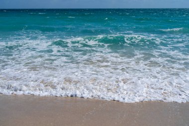Deniz kıyısında dalga hareketi. Yaz okyanus esintisi. Deniz doğası arka planı. Huzurlu okyanus. Rüya gibi okyanus ufku. Kıyı okyanusu cennet duvar kâğıdı. Deniz köpüğü dalgaları. Gök mavisi su yüzeyi. Altın saat kumsalı