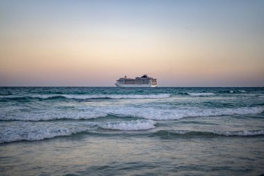 Okyanusta bir gemi turu. Denizde lüks bir yolcu gemisi. Yolcu gemisi olan Miami Plajı. Turkuaz su ve yolcu gemisi. Kıyıya yakın bir turist gemisi. Okyanus dalgaları ve tekne. Yaz tatili. Tekne gezisi