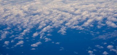 Kabarık bulutlu mavi gökyüzü. Parlak mavi gökyüzü arkaplanı. Bulutlu beyaz bulutlar. Güneşli bir günde sakin bir gökyüzü. Bulutların arasından gün ışığı. Yumuşak bulutlu bahar gökyüzü