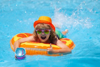 Excited kids face. Little child boy in swimming pool with inflatable toy ring. Children summer vacation. Swim for child on float. Beach sea and water fun