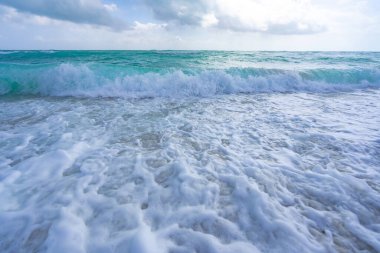 Deniz dalgaları arka planı. Tropik okyanus dalgaları. Mavi deniz manzaralı. Köpüklü sahil şeridi. Kumsal sahili arka planı. Deniz manzaralı duvar kağıdı. Turkuaz su hareketi. Deniz sahili dalgası. Mavi deniz dalgaları