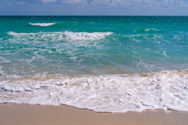 Okyanus dalgaları ve gökyüzünde kum. Fırtınalı deniz dalgaları. Yaz denizi dalgası. Köpüklü okyanus dalgaları. Yaz okyanus esintisi. Rüya gibi yaz sahili geçmişi. Okyanus sıçrama dalgaları