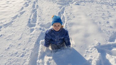 Çocuk ve parkta kar. Çocuk kar yağışında neşeyle oynuyor. Kış çocukları portresi. Mutlu çocuk yüzünde kar taneleri. Soğuk kışın çocukları. Kar oynamak eğlenceliydi. Karlı havada bir çocuk. Kış tatili