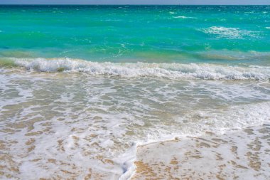 Deniz dalgaları. Yaz dönemi. Okyanus suyu hareketi. Okyanus sıçrama dalgası arka planı. Derin mavi deniz plajı. Turkuaz dalga arka planı. Rüya gibi egzotik deniz sahili arka planı