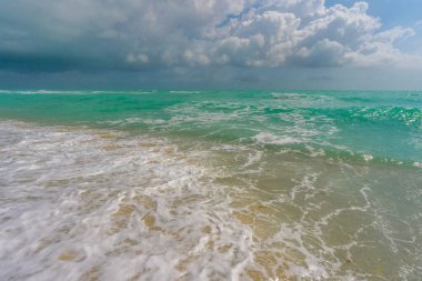 Deniz arka planı. Mavi okyanus. Kumsal kumsalı. Okyanus dalgaları. Yaz mevsimi. Tropik deniz kıyısı. Egzotik turkuaz su. Köpüklü dalga denize sıçrıyor. Güneşli sahil manzarası