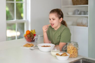 Modern mutfakta sağlıklı yiyecekler yiyen çocuklar. Modern mutfakta taze sebzelerin tadını çıkaran mutlu çocuklar. Modern mutfakta vejetaryen yemeği yiyen sevimli çocuklar. Mutfağın içi.