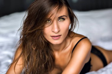 Sabahleyin yatakta sevimli gülümseyen güzel kadın. sevinç, sakin ol, mutluluk