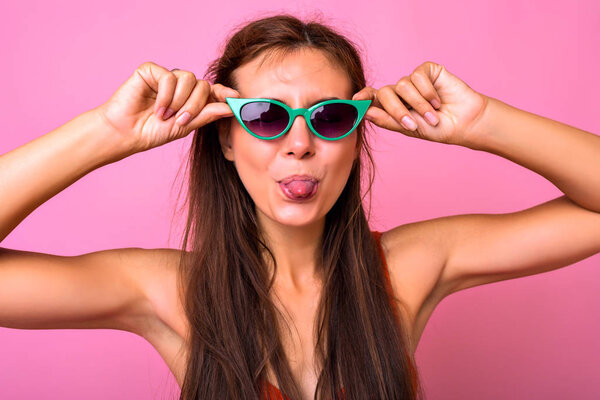 Young beautiful woman posing in studio  sticking out tongue 