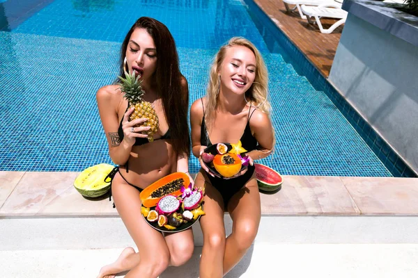 two best friends girls with a lot of different tasty exotic fruits, health vegan lifestyle