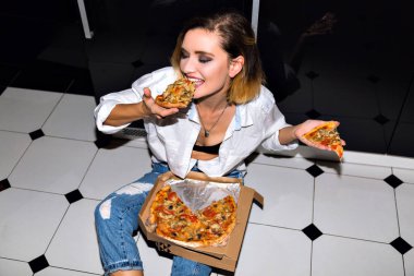 Güzel genç bayan pizza yiyor. 