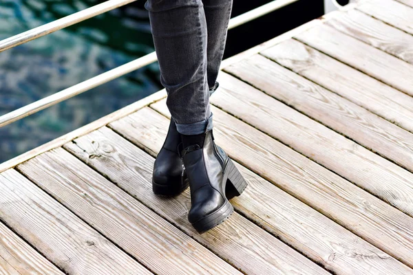 穿着黑色靴子的年轻女子在河边 — 图库照片
