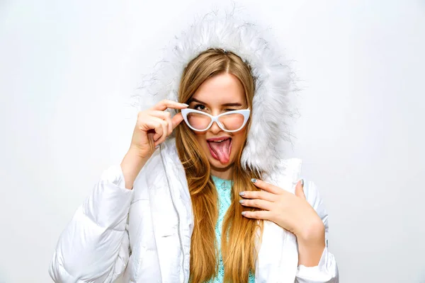 Красива Молода Жінка Білому Пальто Позує Студії Показуючи Язик — стокове фото