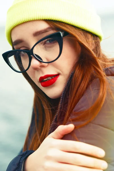 Attractive Young Woman In Glasses And Knitted Cap. Red Lipstick