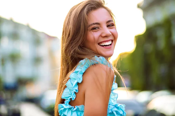 路上でポーズをとる青いドレスの美しい女性を笑顔 — ストック写真