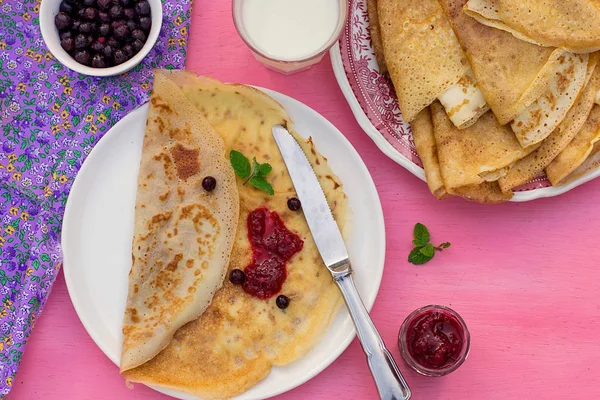 Sweet thin pancakes crepes served with raspberry jam