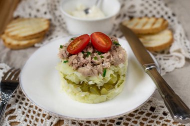 Haşlanmış rendelenmiş patates, peynir, turşu ve konserve morina karaciğer katmanlı salata oluşan