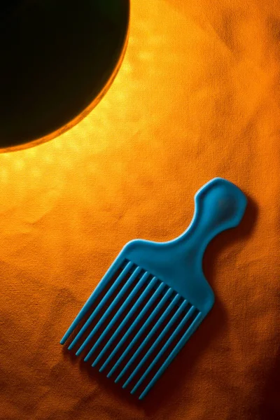 Turuncu kumaş kuaför aletinde mavi plastik afro tarak