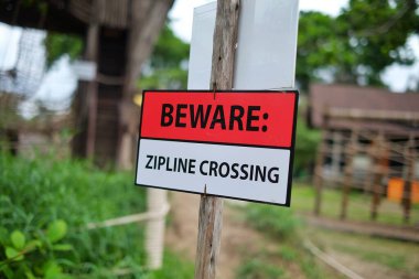 Yürüyüşçülerin yasak bölgeye girmesini önlemek için yukarıdan geçen bir halat hattını gösteren bir uyarı..