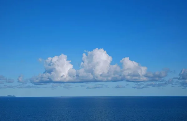 Blick Auf Ein Ruhiges Blaues Meer Mit Weißen Flauschigen Wolken — Stockfoto
