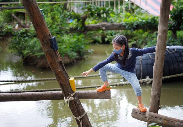 Küçük bir kanalı geçmeye çalışan genç, sevimli bir Asyalı kız. Kereste yapısından geçerek hedefine ulaşmak için cesur ama ihtiyatlı..