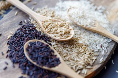 Siyah pirinç, esmer yabani pirinç ve tahta kaşık düzlüğünde beyaz yasemin pilavı. Yaratıcı düzen. Yemek konsepti. Esmer pirince odaklan..