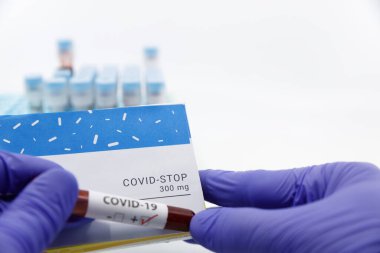Doktor, arka planda kan tahlili tüpleri ile kovid tıbbı durdurma kavramı gösterdi. Coronavirüs için tedavi, COVID-19.