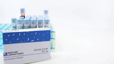 Doktor, covid-19 tedavisi için ilaç kutusunu gösteriyor. Arka planda kan testleri tüpleri bulunan covid tıbbı kavramı. Coronavirus, COVID-19 tedavisi için tedavi.