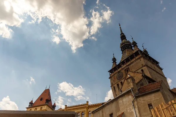 SIGHISOARA, ROMANIA - 2020 dolaylarında bulutlu mavi gökyüzüne sahip eski bir ortaçağ kasabası. Doğu Avrupa 'da güzel bir turistik yer. Romanya Sighisoara 'daki ünlü ortaçağ saat kulesi