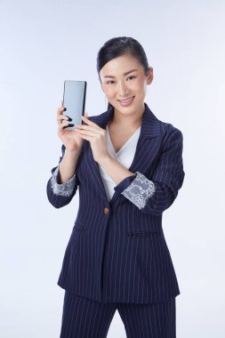 Seç birini! Teknoloji, cep telefonu, iletişim için ekipman. Genç ve güzel bir kadın kamerada beyaz arka planda boş akıllı telefon ekranını gösteriyor.