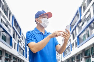 Dışarıda mikrop ve virüslerden korunmak için maske takan bir adam var. Toz önleme ve zehirli gazların önlenmesi