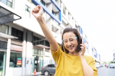 Soğuk algınlığı, grip ve virüslerden korunmak için yüz maskesi takan mutlu kadın portresi. Sokakta maskeli genç bir kadın. Şehirdeki hava kirliliği yüzünden maske takan kadın.