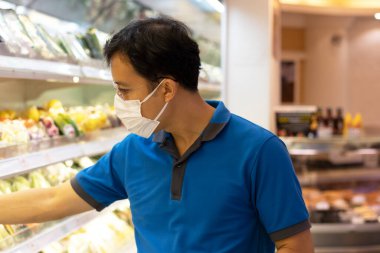 Asyalı erkekler süpermarketlerde maske alışverişi yaparlar