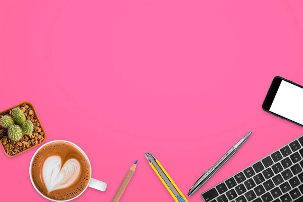 Ahşap ofis masası bilgisayar klavye, kalem, kurşun kalem, smartphone, sıcak kahve ve kesici bıçak ile üstten görünüm pembe bir arka plan üzerinde.
