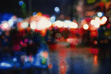 Yağmurlu gece şehir arka planda penceresindeki yağmur damlası.