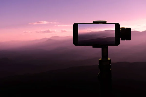 스마트폰을 사진을 일몰에 산에서 삼각대에 여행자 — 스톡 사진