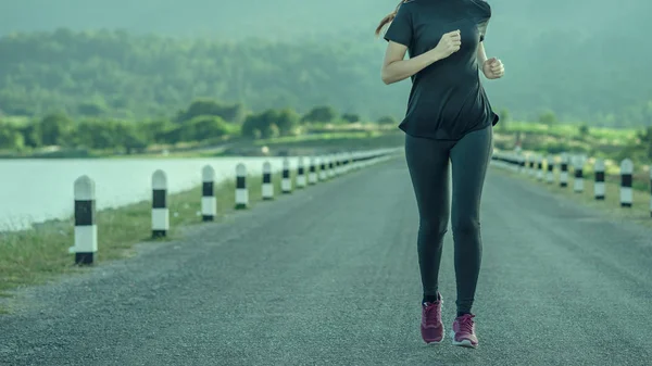 Mujer Joven Está Corriendo Carretera Por Mañana Con Las Montañas —  Fotos de Stock