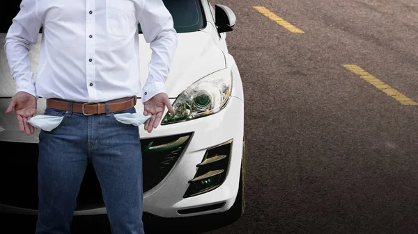 Man showing his empty pockets with white car background. — Stock Photo, Image