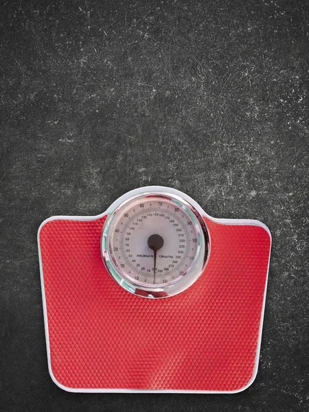 Red scales on black floor texture background.