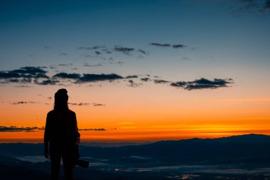 Kamerayı tutan genç hipster fotoğrafçının arka görünümü 