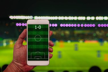 Blur futbol Stadi üzerinde futbol alanı ile el tutarak Smartphone