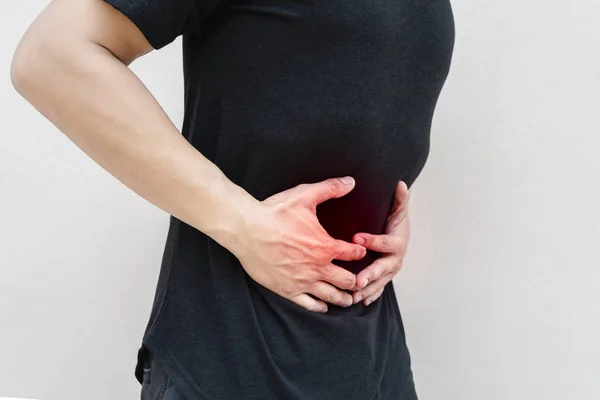 Giovane uomo tenendo il suo stomaco nel dolore . — Foto Stock