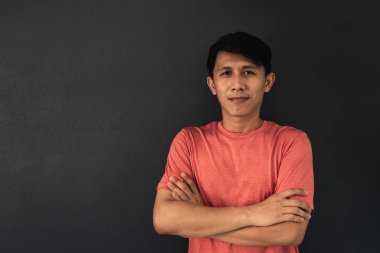 Siyah duvar arka plan üzerinde kırmızı boş t-shirt Asyalı adam.