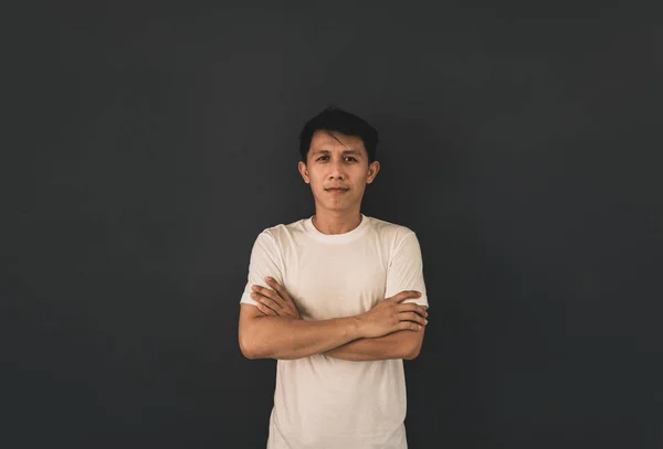 Chico asiático en blanco camiseta en blanco sobre fondo de pared negro . — Foto de Stock