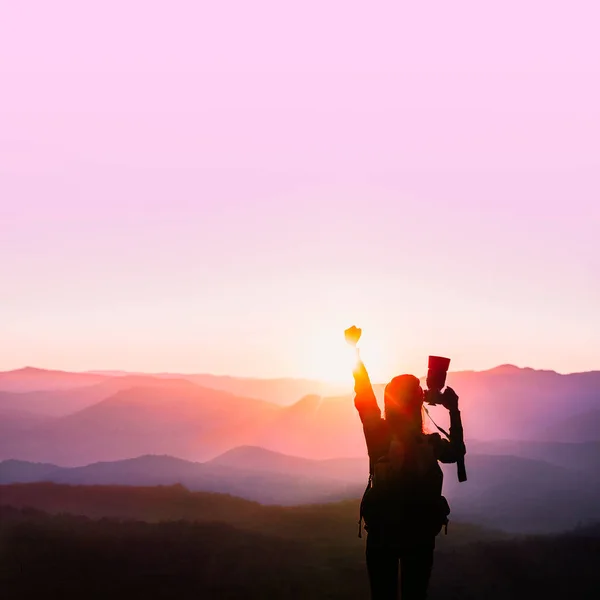 Jovem viajante mulher levantar as mãos para o seu sucesso com o pôr do sol no fundo natural da montanha . — Fotografia de Stock