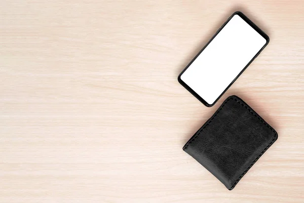 Smartphone e carteira no fundo da mesa de madeira . — Fotografia de Stock