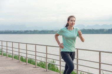 Sabah nehir manzarası ile sokakta çalışan genç kadın.