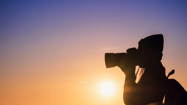 Jonge vrouw fotograaf het nemen van foto met zonsondergang op berg natuurlijke achtergrond. — Stockfoto