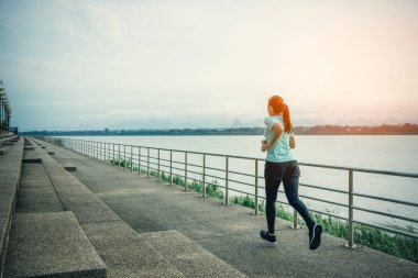 Sabah nehir manzarası ile sokakta çalışan genç kadın.