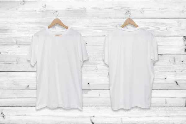 White blank front and back t-shirt on white wood wall background.